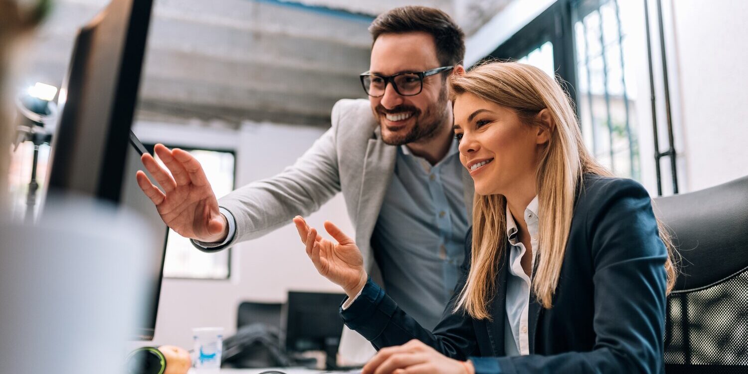 Working together on project. Two young business colleagues working on computer